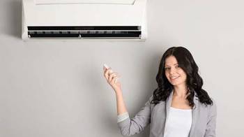 Lady pointing remote at air conditioner